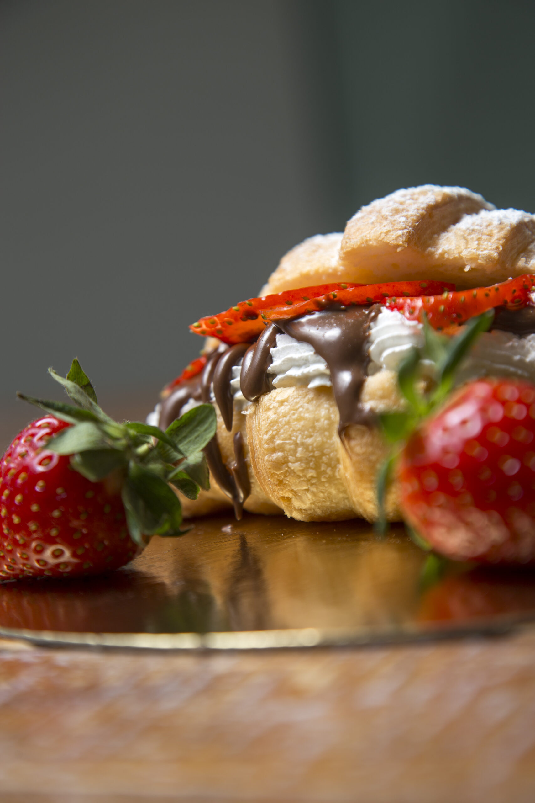 Primer plano de croissant de chocolate, fresa y nata. Trabajo para pastelería.